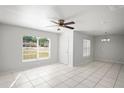 Bright living room with tile floors, a ceiling fan, and plenty of natural light from large windows at 1225 Harvest Home Ct, Ruskin, FL 33570