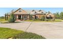 Exterior elevation of a home with circular driveway, three car garage, and manicured landscaping at 13206 Lewis Raulerson Road, Dover, FL 33527