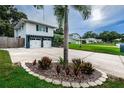 Long driveway leading to a two-car garage, surrounded by neatly kept landscaping and green lawns at 13548 Bellewood Ave, Seminole, FL 33776