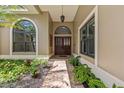 Elegant front entrance with a decorative door, sidelights, and beautiful plantings at 2136 Pinnacle N Cir, Palm Harbor, FL 34684