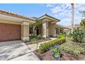 Attractive home facade showcasing the front walkway and vibrant landscaping at 2136 Pinnacle N Cir, Palm Harbor, FL 34684