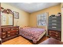 Cozy bedroom with warm tones, a patterned bedspread, and matching wood furniture at 2410 E Palifox St, Tampa, FL 33610