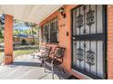 Inviting front porch with seating, brick columns, and secure iron door, offering a welcoming entrance at 2410 E Palifox St, Tampa, FL 33610