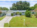 Charming single-story home with a well-manicured lawn, mature trees, and inviting curb appeal at 2523 Blackwood Cir, Clearwater, FL 33763