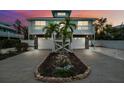 Charming two-story coastal home with dual garages, balcony, stone accents, palm trees, and a well-kept lawn at 311 Poinsettia Rd, Anna Maria, FL 34216