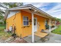 Side view of an orange home with a cozy porch and decorative accents at 40111 Pretty Redbird Rd, Zephyrhills, FL 33540