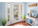 Inviting entryway with a decorative glass door, beach themed decor, and wood flooring at 6327 Sunset Bay Cir, Apollo Beach, FL 33572