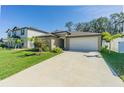 Charming single-Gathering home featuring a two-car garage, well-maintained lawn, and inviting curb appeal at 6494 Beverly Hills Dr, Zephyrhills, FL 33541