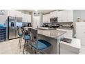 Modern kitchen featuring granite countertops, stainless steel appliances, an island with barstool seating at 6494 Beverly Hills Dr, Zephyrhills, FL 33541