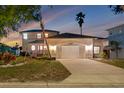 Inviting exterior of the home with a two-car garage, manicured lawn, and mature palm trees at 6606 Dolphin Cove Dr, Apollo Beach, FL 33572