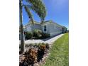 Well-maintained home with lush landscaping, a paver walkway, and a view of the sky at 953 Crosswind Ave, Sarasota, FL 34240