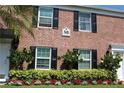 Townhome featuring brick exterior with black shutters and well manicured landscaping at 13736 Orange Sunset Dr, Tampa, FL 33618