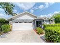 Home featuring a two-car garage, stone accents, and manicured landscaping, providing a welcoming entrance at 14501 Brambie Ct, Tampa, FL 33624