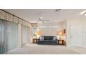 Spacious living room featuring neutral carpet, a ceiling fan, and sliding doors to the outdoors at 2129 Acadia Greens Dr, Sun City Center, FL 33573