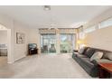 Bright living room with neutral carpet, ceiling fan, and sliding doors to a patio at 2129 Acadia Greens Dr, Sun City Center, FL 33573