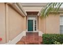 Inviting front entrance with a brick pathway leading to a stylish green door with sidelights at 2243 Worthington Greens Dr, Sun City Center, FL 33573