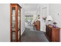 Inviting hallway with neutral paint, plush carpet, and decorative furniture leading to a bright living area at 2243 Worthington Greens Dr, Sun City Center, FL 33573