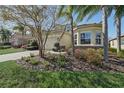 Charming home featuring a brick driveway, two-car garage, and mature landscaping in a well-maintained yard at 30280 Southernwood Ct, Wesley Chapel, FL 33543