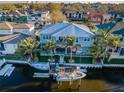 Waterfront home boasts a metal roof, balcony, lush backyard, and a private boat dock with boat lift on a wide canal at 315 Manatee Ln, Tarpon Springs, FL 34689