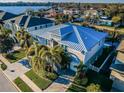 A beautiful two-story home with a metal roof and a manicured lawn is seen from the side, boasting waterfront access at 315 Manatee Ln, Tarpon Springs, FL 34689