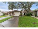 Charming single Gathering home showcasing a well manicured lawn and attached one car garage at 318 Parkside Ln, Safety Harbor, FL 34695