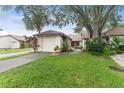 Charming single Gathering home showcasing a well manicured lawn and attached one car garage at 318 Parkside Ln, Safety Harbor, FL 34695