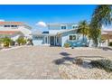 Charming home with a neatly paved driveway, tropical landscaping, and a serene, inviting curb appeal at 330 176Th Avenue Cir, Redington Shores, FL 33708