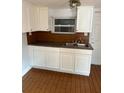 An efficient kitchen features white cabinets, laminate countertops, and a stainless steel sink, blending functionality with streamlined design at 3718 19Th S Ave, St Petersburg, FL 33711