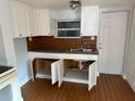 A modest kitchen reveals white cabinets, laminate countertops, and a stainless steel sink for streamlined cooking and cleanup at 3718 19Th S Ave, St Petersburg, FL 33711