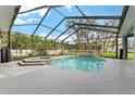 Screened-in pool area featuring a built-in spa, perfect for relaxation at 37350 Neighbors Path, Zephyrhills, FL 33542