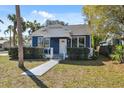 Quaint blue home with lush green lawn and a welcoming walkway to the entrance at 502 W Hanna Ave, Tampa, FL 33604