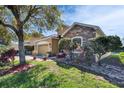Beautiful home with manicured lawn, stone accents, and lush landscaping creating great curb appeal at 6432 Twin Bridges Dr, Zephyrhills, FL 33541
