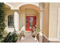 Inviting front entrance with a red door, columns, and charming potted plants, welcoming you home at 8057 Rio Bella Pl, Bradenton, FL 34201