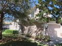 Two-story home featuring a two-car garage and lush green landscaping at 829 Lantern Way # 829, Clearwater, FL 33765