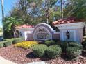 Community entrance sign with lush landscaping at Coachman Reserve at 829 Lantern Way # 829, Clearwater, FL 33765