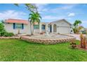 Charming single-story home with a red roof and lush landscaping, including a decorative fountain at 922 Sago Palm Way, Apollo Beach, FL 33572