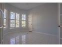 Bedroom features light-colored walls, bright windows, tile flooring, and a standard door at 10411 Cory Lake Dr, Tampa, FL 33647