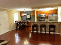 Open kitchen/dining area featuring a breakfast bar with stone accents, stainless steel appliances, and wood floors at 105 S Obrien St # 216, Tampa, FL 33609