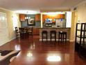 Open-concept living room with hard wood floors, breakfast bar, kitchen, and dining area at 105 S Obrien St # 216, Tampa, FL 33609