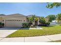 Charming single-Gathering home featuring a well-maintained lawn, mature trees, and a two-car garage at 11749 Summer Springs Dr, Riverview, FL 33579