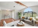 Bright living room featuring a large arched window, wood floors, and stylish, neutral-toned furnishings at 14048 Bruni Dr, Spring Hill, FL 34609