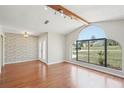 Bright living room featuring a large arched window and beautiful wood floors at 14048 Bruni Dr, Spring Hill, FL 34609