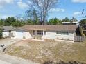 Single-story home with attached garage, featuring brick accents and manicured flower beds at 4209 Westwood Dr, Holiday, FL 34691
