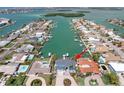 Aerial view of a canal front home with a private boat dock; nearby islands are visible in the distance at 440 Capri Blvd, Treasure Island, FL 33706