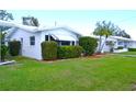 Well-maintained home featuring a green lawn and manicured shrubs and flower, all adding to its curb appeal at 4517 100Th N Ave, Pinellas Park, FL 33782