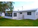 Backyard featuring a well-maintained green lawn and a sunroom attached to the rear of the house at 4517 100Th N Ave, Pinellas Park, FL 33782