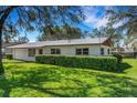 Exterior view of a well-maintained single-story home featuring a new metal roof and verdant front yard at 4814 Edmund Ct, Dover, FL 33527