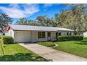 Charming single-story home with a metal roof, an attached garage, and a well-manicured front yard at 4814 Edmund Ct, Dover, FL 33527