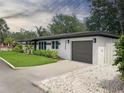 Charming single-story home with a well-manicured lawn and a paved driveway leading to an attached garage at 525 Lamara Ne Way, St Petersburg, FL 33704