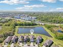 Aerial view showcasing the property's location near a pond, surrounded by lush greenery and residential homes at 5955 Sweet Birch Dr, Riverview, FL 33578